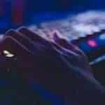 A person's hand is typing on a computer keyboard.