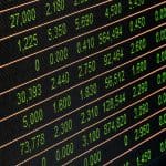 A close up of a stock board with many numbers on it.
