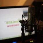 A microphone in front of a computer screen.