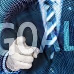 A businessman pointing to the word goal.